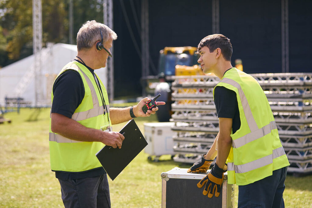 Event Production Team with Headsets Setting Up Outdoors